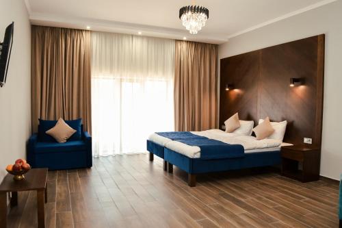 a bedroom with a blue bed and a blue chair at Villa Alfredo in Odesa