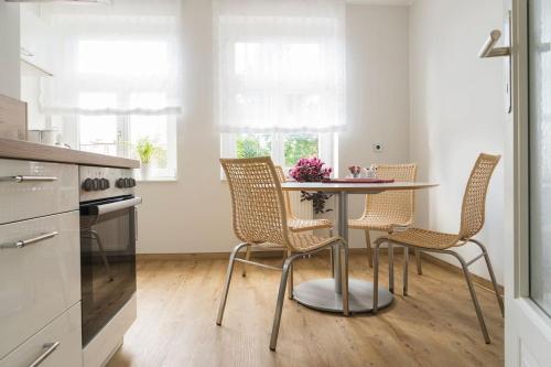 een keuken met een tafel en stoelen in een kamer bij Gästehaus Ritter & Pacia, Ferienwohnung 2. Etage in Sangerhausen