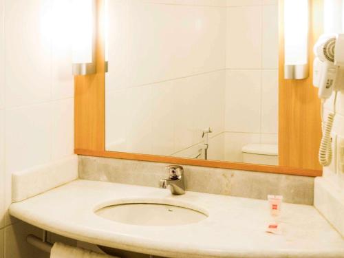a bathroom with a sink and a mirror at ibis Petrolina in Petrolina