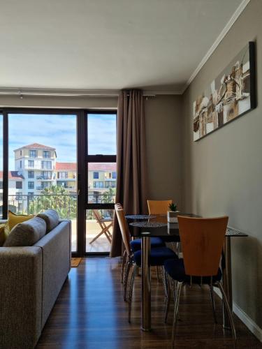 a living room with a couch and a table with chairs at Island Club by Smart City Stays in Cape Town