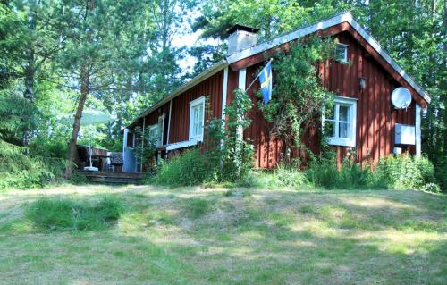 a small red house in the middle of a yard at Schwedentraum Varpstugan in Kisa