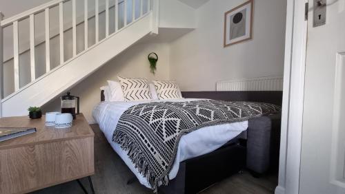 a bedroom with a bed with a black and white comforter at Haxby House by Switchback Stays in Cardiff
