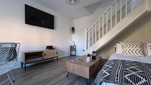 a bedroom with a bed and a tv on the wall at Haxby House by Switchback Stays in Cardiff