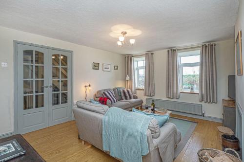 a living room with two couches and a table at Llys Awel in Llangadwaladr