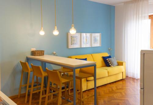 a living room with a yellow couch and a table and chairs at Sorrento Central and Sea View Flats in Sorrento