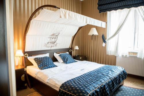 a bedroom with a canopy bed with blue pillows at Shuma in Dąbrowa Górnicza