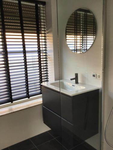 a bathroom with a sink and a mirror at Chic appartement in Sas van Gent in Sas van Gent