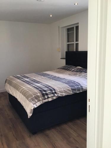 Schlafzimmer mit einem Bett mit einer blauen und weißen Bettdecke in der Unterkunft Chic appartement in Sas van Gent in Sas van Gent