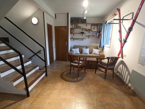 a living room with a table and chairs and a staircase at Apartament a La Molina, grans vistes, llar de foc in La Molina