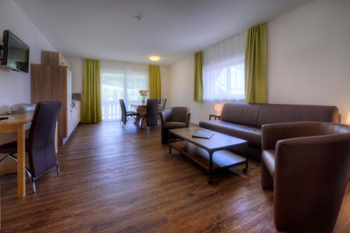 a living room with a couch and chairs and a table at Alpenstern rooms & suites in Lermoos