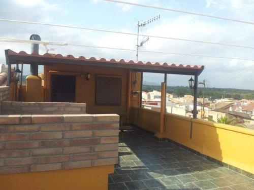 une maison jaune avec un toit et une terrasse couverte dans l'établissement Manxalo, à Sant Mateu