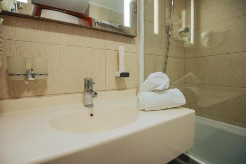 a bathroom with a sink with a towel on it at Grand Hotel Tuzla in Tuzla