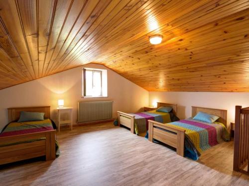 um quarto com 2 camas e um tecto de madeira em Gîte La Chambonie, 4 pièces, 6 personnes - FR-1-496-196 em La Chambonie
