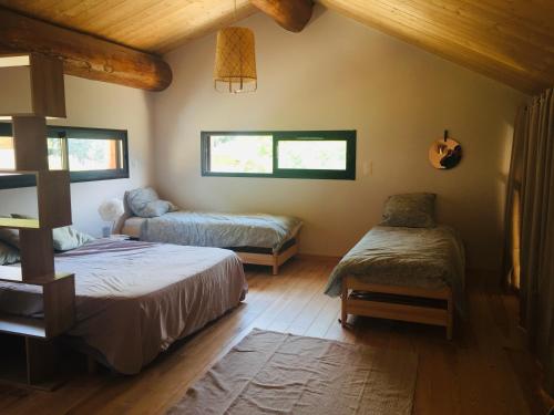 1 dormitorio con 2 camas y 1 silla en Spacieux logement Ax-les-thermes, en Ax-les-Thermes
