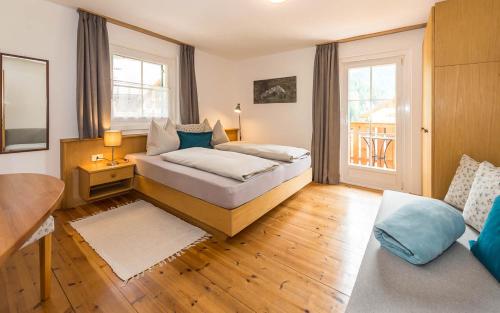 Haus Claudia في نوفا ليفانتي: غرفة نوم بسرير وطاولة واريكة