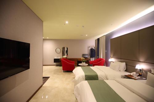 a hotel room with a bed and a flat screen tv at Gimpo Stavia in Gimpo