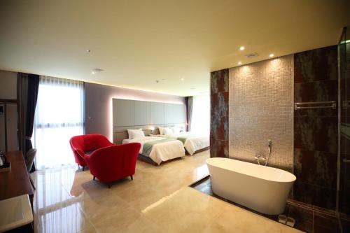 a bathroom with a bed and a tub in a room at Gimpo Stavia in Gimpo