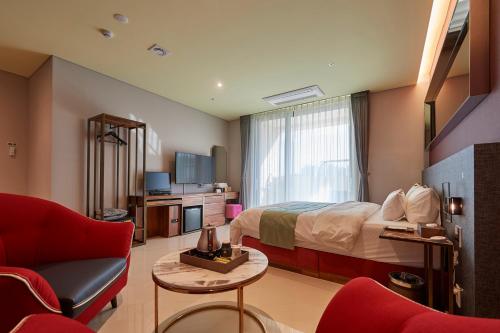 een hotelkamer met een bed en een bank bij Gimpo Stavia in Gimpo