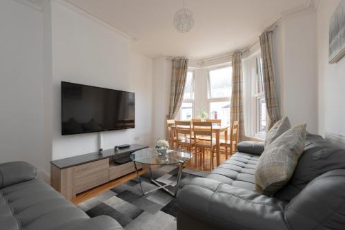 a living room with a couch and a flat screen tv at Fortified Home Rochester in Rochester