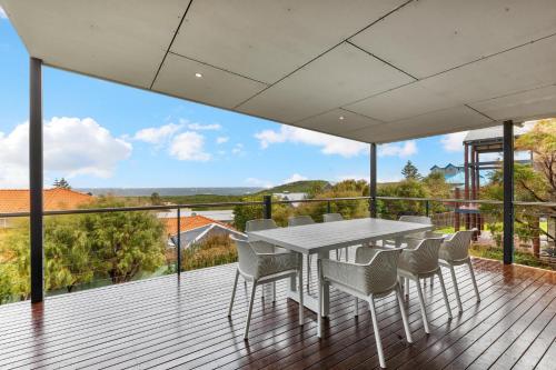 a white table and chairs on a deck with a view at Beachside at Margaret River - Spacious Family Beach House in Exclusive Prevelly Location in Prevelly