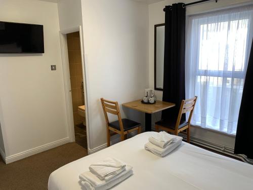 a room with a bed and a table and a window at The Royal Clarence Hotel (on the Seafront) in Burnham on Sea