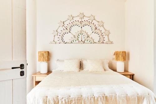 a bedroom with a white bed with two lamps at Masseria Calderisi in Savelletri di Fasano