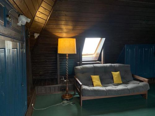 a couch in a room with a lamp and a window at Садиба Остра in Sherbovtsy