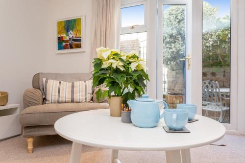 una sala de estar con una mesa blanca con una planta. en Modern Mews House with Free Parking Space, and Patio by Huluki Sussex Stays, en Brighton & Hove