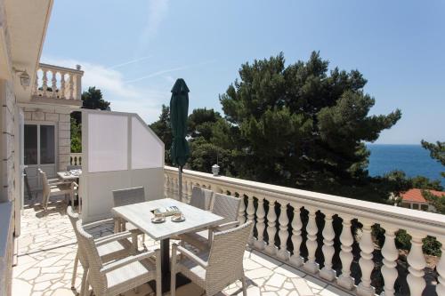 a patio with a table and chairs on a balcony at Apartments Villa Dingač in Gornji Dingač