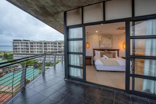 a bedroom with a bed on a balcony at Stay at The Point - Peaceful Plentiful Penthouse in Durban