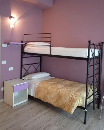 two bunk beds in a room with purple walls at Ostello La Sosta in Contrada Anselmi