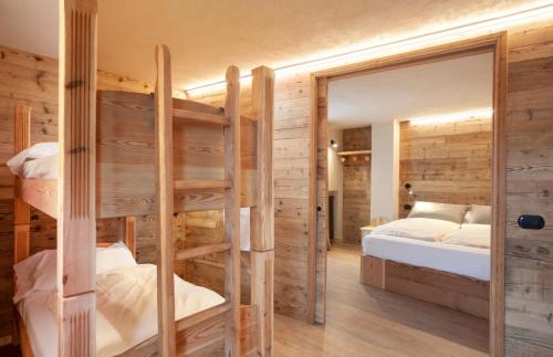 サウゼ・ドゥルクスにあるHotel Stella Alpinaのベッドルーム1室(二段ベッド2台、鏡付)