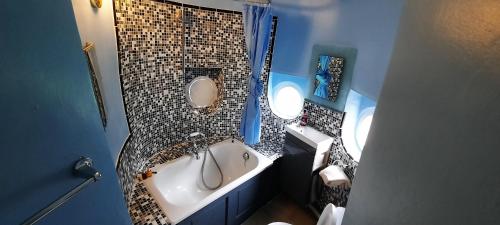 a bathroom with a tub and a round mirror at Lickleyhead Castle in Insch