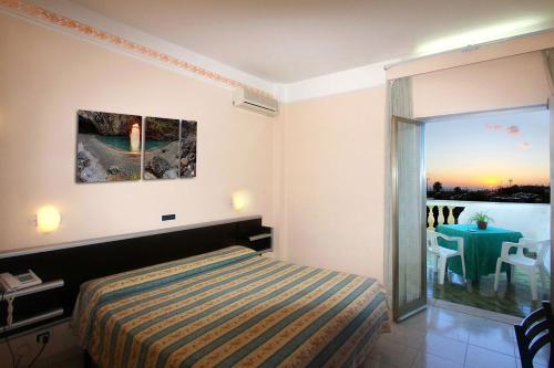 - une chambre avec un lit et une vue sur une table dans l'établissement Hotel Parco Dei Principi, à Scalea