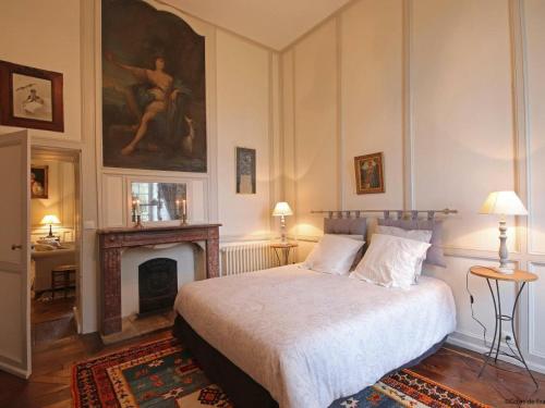 ein Schlafzimmer mit einem Bett, einem Kamin und einem Gemälde in der Unterkunft Gîte Le Grais, 3 pièces, 4 personnes - FR-1-497-13 in Le Grais
