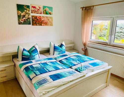 a bedroom with a bed with blue pillows and a window at Ferienwohnung IRMGARD in Goseck