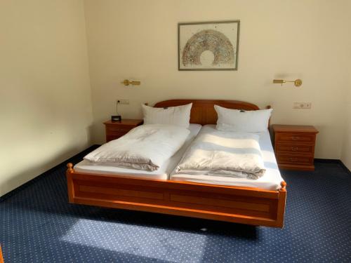 a bedroom with a bed with white sheets and pillows at DAS LOFT Hotel Hölsterloh in Brilon
