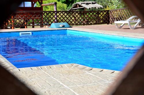 een zwembad met blauw water in een tuin bij Quebrada del Viento - Cabañas in Los Hornillos