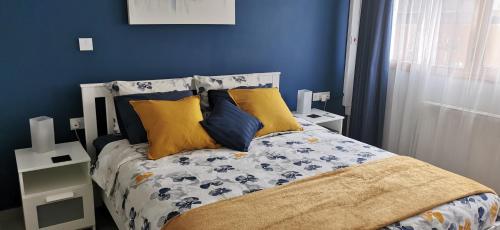 a bedroom with a bed with blue walls and yellow pillows at Elegant & Trendy Apt in a Peaceful Area in Limassol