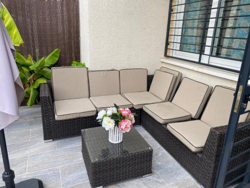 a patio with two chairs and a table with a vase of flowers at Duplex de lujo en la playa , jacuzzy, piscina, chimenea y padel in Benalmádena