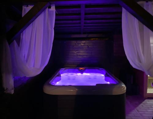 bañera con luces moradas en una habitación en SG chalupa MLÁZOVICE 1 se soukromým wellness v ceně en Mlázovice