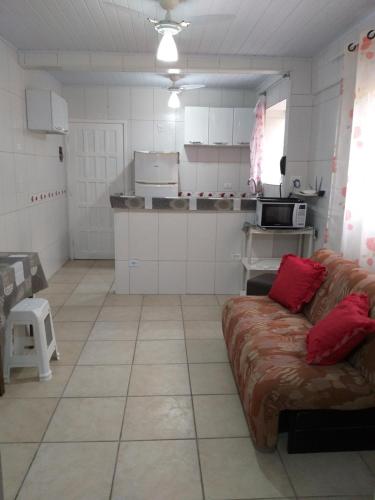 Il comprend un salon avec un canapé et une cuisine. dans l'établissement Kitnet para Temporada no Litoral SP, à Praia Grande