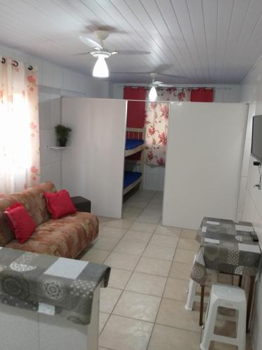 - un salon avec un canapé et une table dans l'établissement Kitnet para Temporada no Litoral SP, à Praia Grande