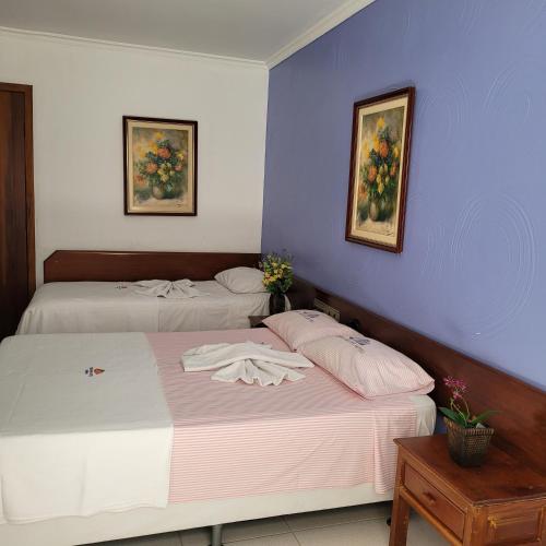 two beds sitting next to each other in a bedroom at Hotel Terra Mater in Porto Seguro