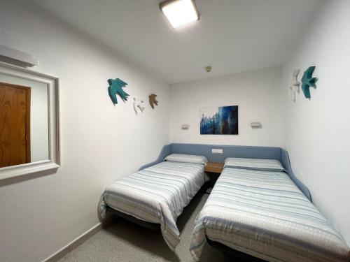 a bedroom with two beds and a window at Tamarán 309 in Playa del Ingles