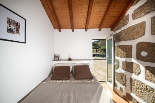 een kamer met 2 bedden en een stenen muur bij Family Room - Quinta do Mirante in Castelo de Paiva