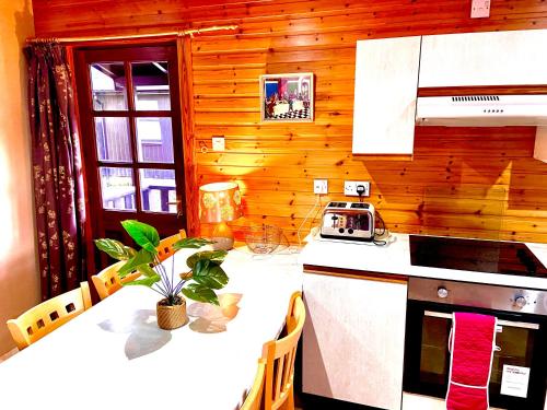 a kitchen with a table with a stove and a counter top at Braemar Lodge Cabins in Braemar