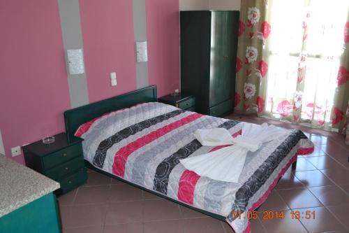 a bedroom with a bed with a striped blanket at Ilias Studios in Patitiri