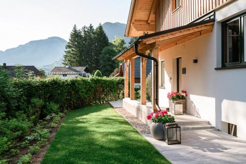 a house with a yard with green grass and flowers at DAS SALZBERG Hideaway Bad Aussee - Adults only in Bad Aussee