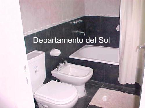 een badkamer met toilet, wastafel en bad bij Departamentos del Sol in Necochea